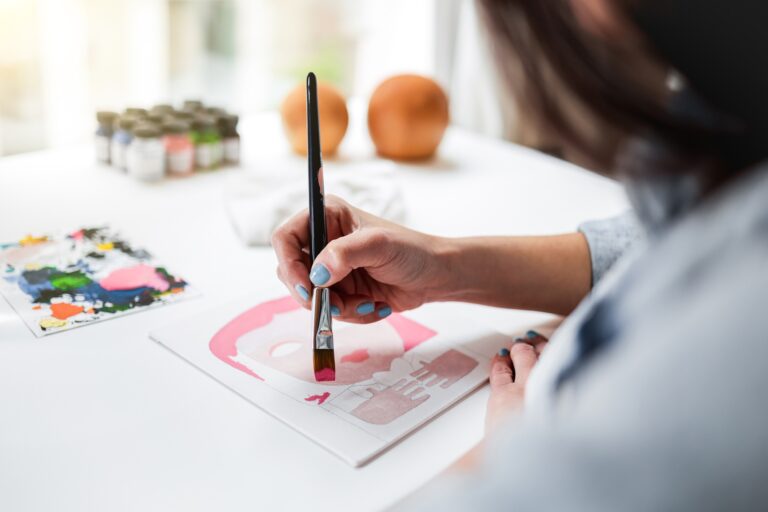 Artist painting on canvas inside school studio - Education and art life style